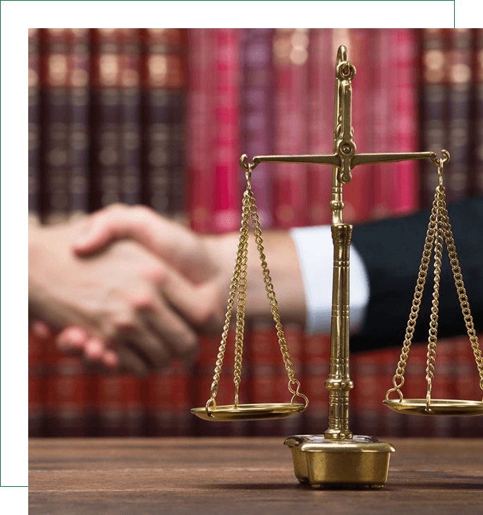 A close up of a law scale with two people shaking hands in the background