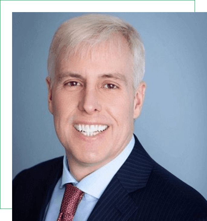 A man with white hair and wearing a suit.