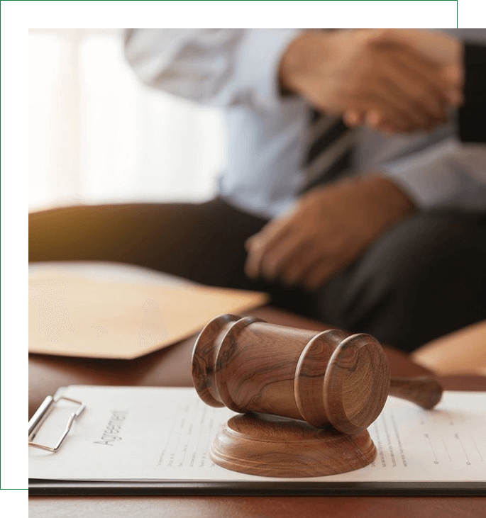 A judge 's gavel sitting on top of papers.